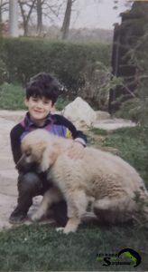 Alen Stefanovic as young boy hugging a Sarplaninac puppy outdoors, showing a strong bond and trust.