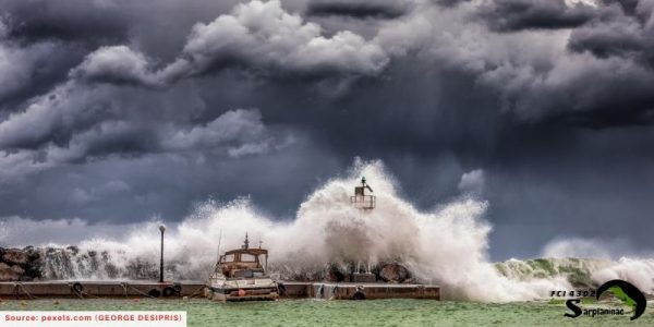 Large waves and storm clouds hitting a lighthouse and a boat.